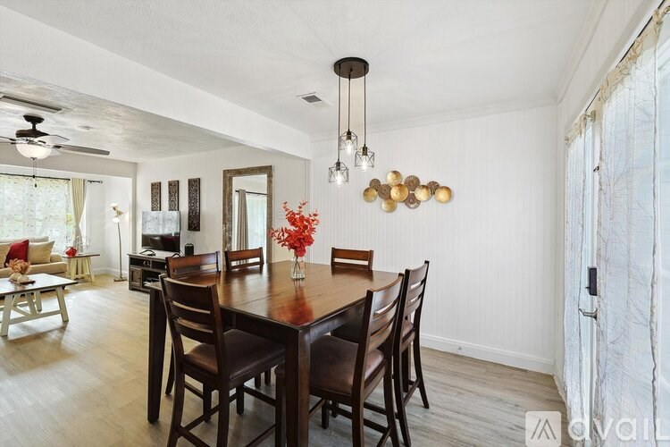 A dining room with a wooden table and chairs.