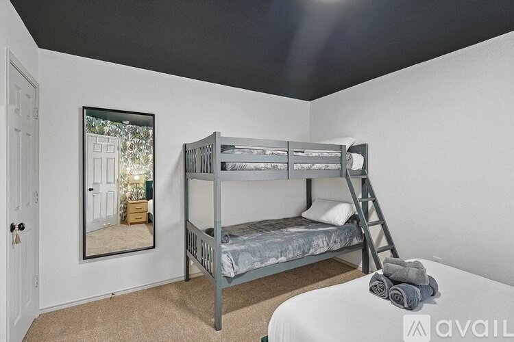 A bedroom with a bunk bed and a ladder.