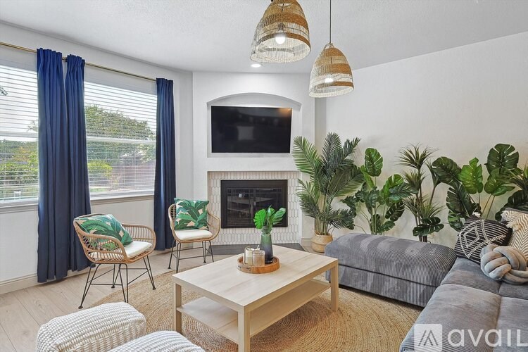 A living room with a grey couch, a wooden coffee table, a fireplace, and a television.