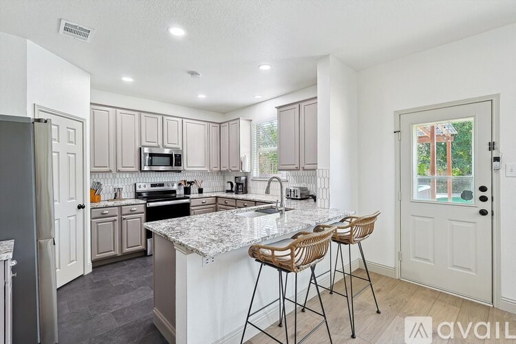 A kitchen with a marble countertop and modern appliances.
