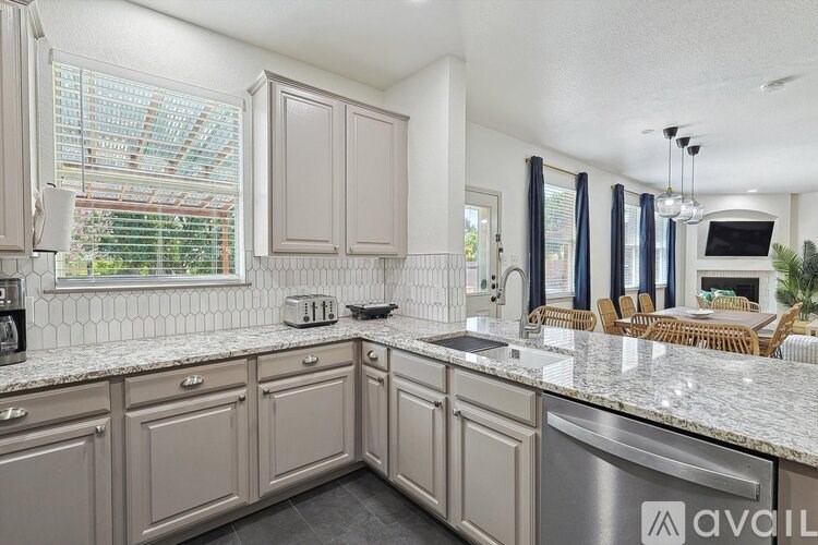 A kitchen with a granite countertop and a dishwasher.