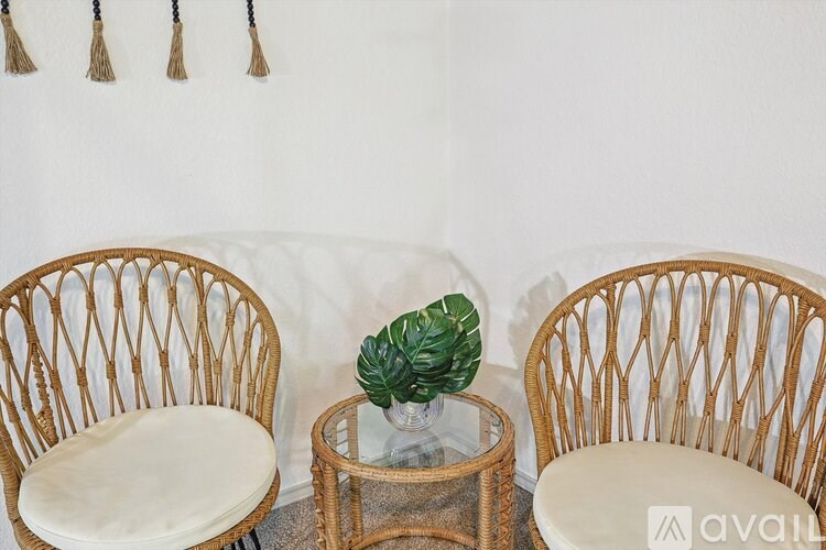 Two chairs and a table with a plant on it.