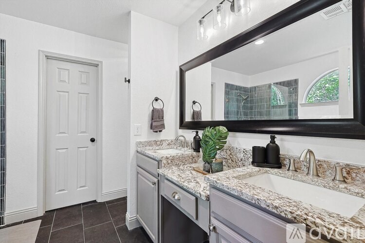 A bathroom with a white door and a marble countertop.