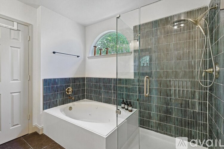 A bathroom with a white tub and a glass shower.