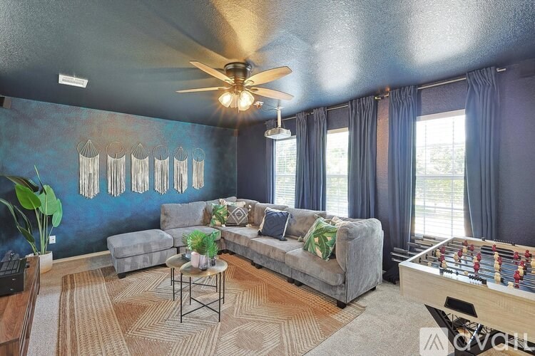 A living room with a grey couch, a coffee table, and a foosball table.