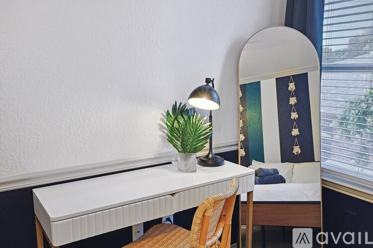 A white desk with a plant and a lamp on it.