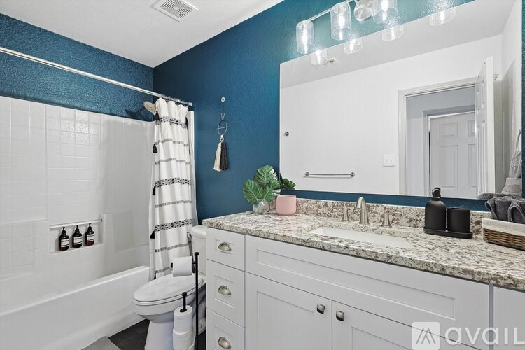 A bathroom with blue walls and a white tub.