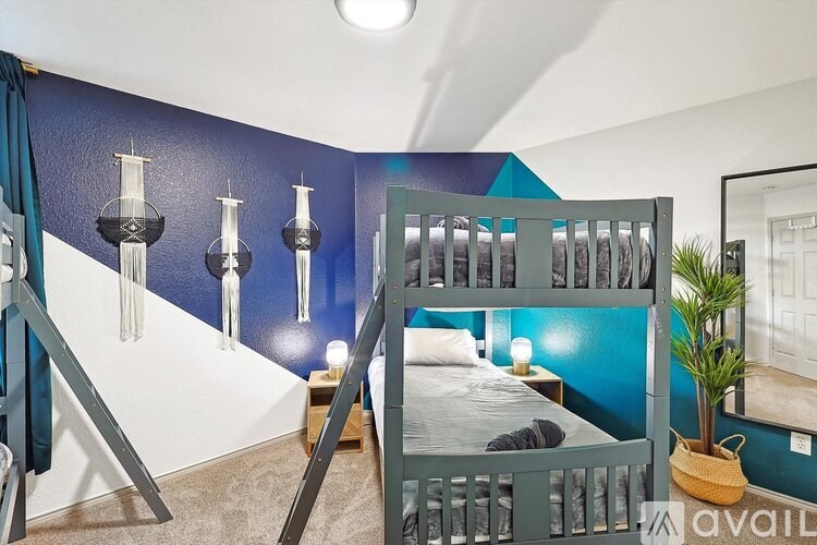A bedroom with a bunk bed and a blue wall.