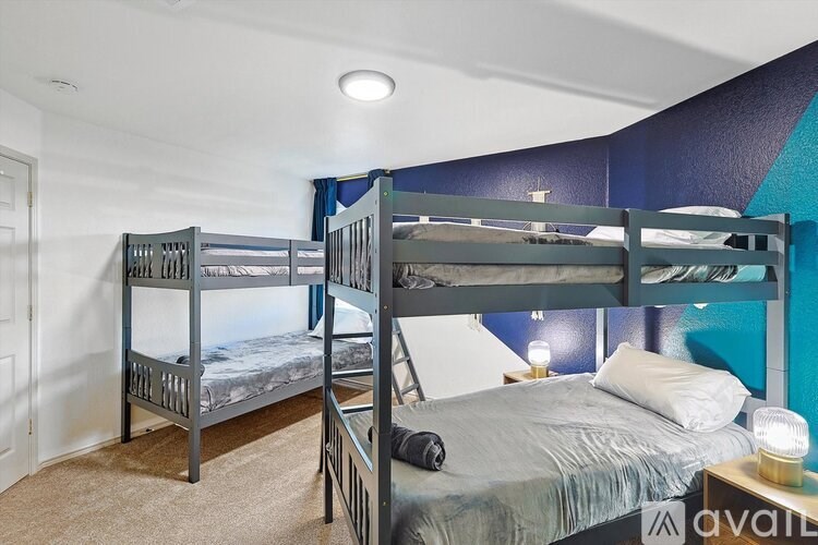 A bedroom with two bunk beds and a single bed.