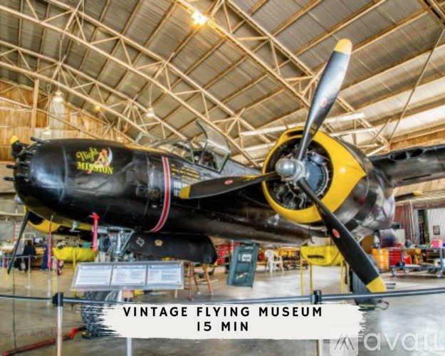 A black and yellow propeller plane is on display in a museum.
