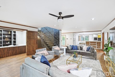 A living room with a grey couch and a wooden wall.