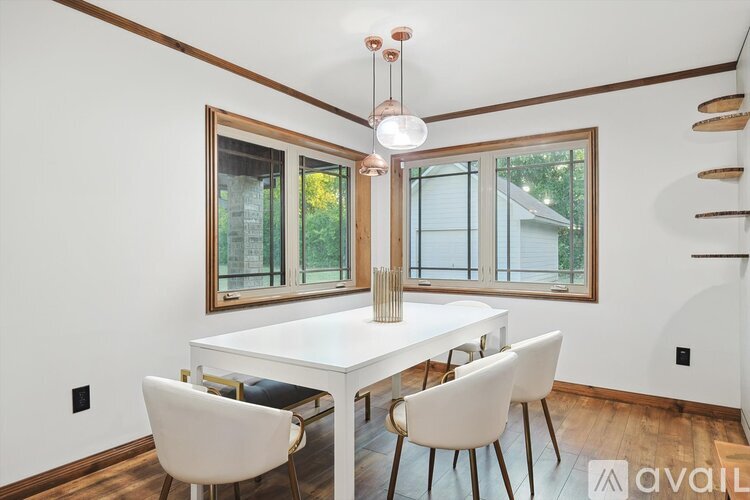 A dining room with a white table and chairs.