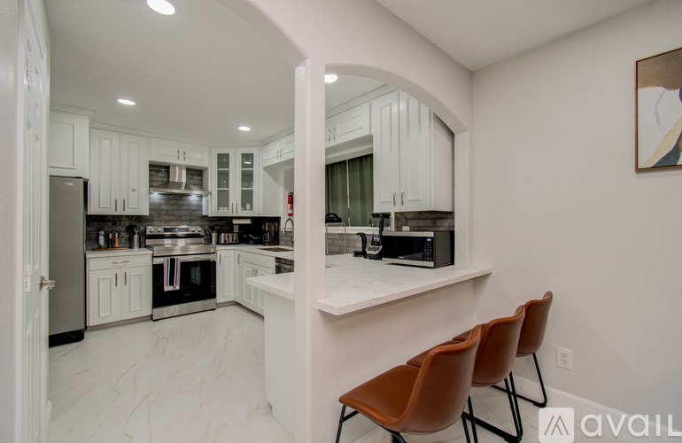 A modern kitchen with white cabinets and a large island.