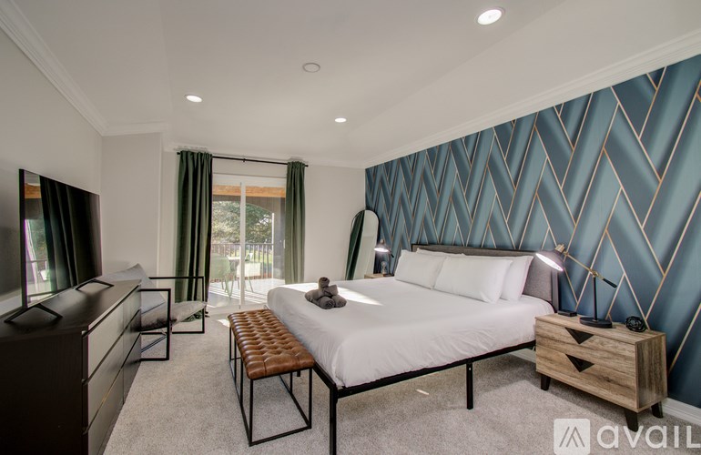 A bedroom with a large bed and a wooden bench.