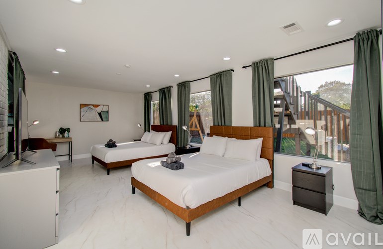 A bedroom with two beds and a television.