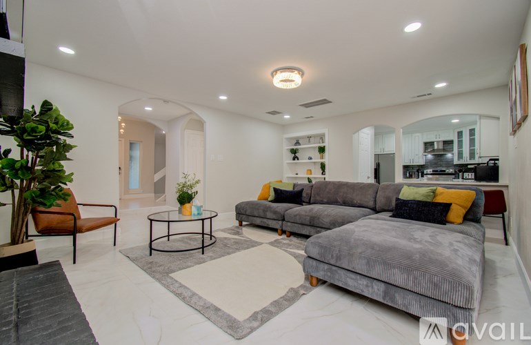 A modern living room with a grey sofa and a coffee table.