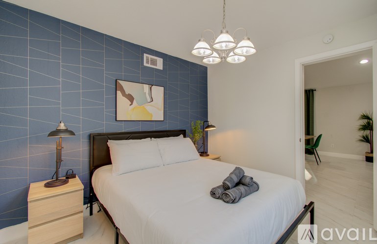 A bedroom with a bed, nightstand, and lamp.