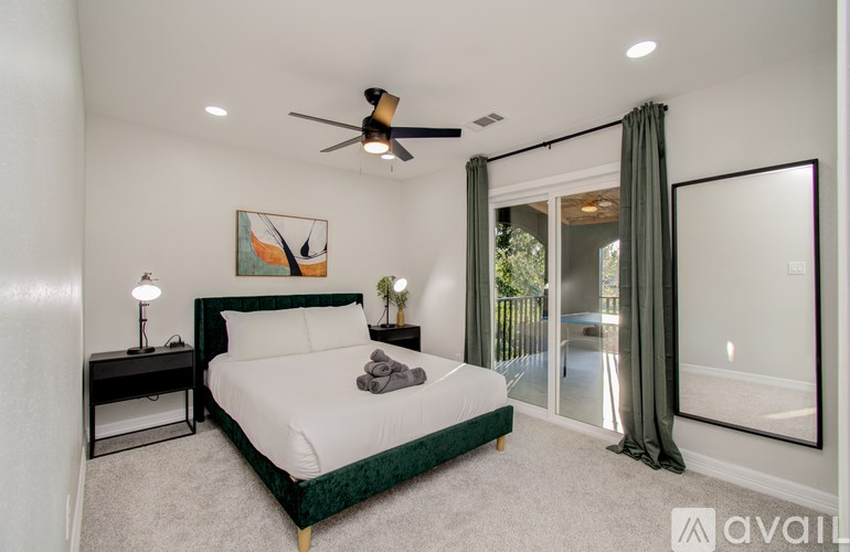 A bedroom with a bed, nightstand, and a painting of a bird on the wall.