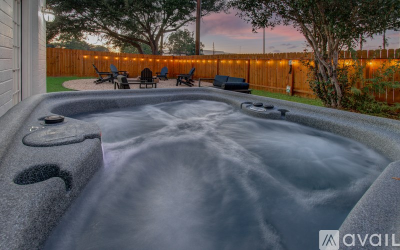 A hot tub sits in the middle of a backyard.