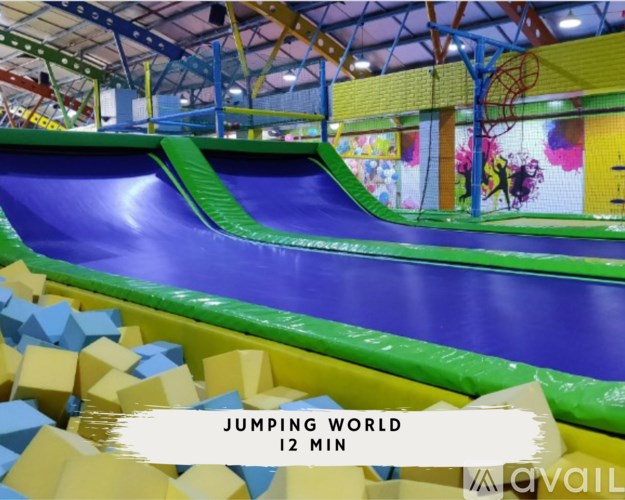 A colorful indoor trampoline park with the text "JUMPING WORLD 12 MIN".