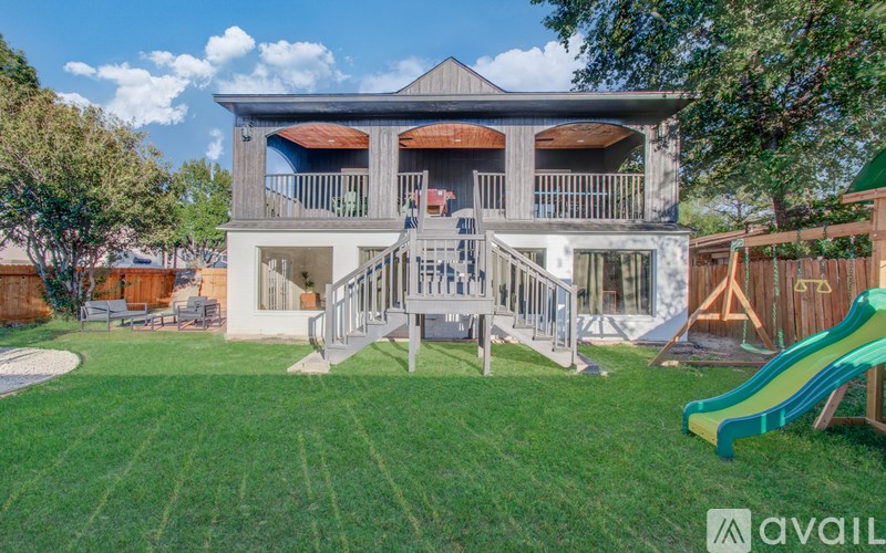 A house with a green slide in the yard.