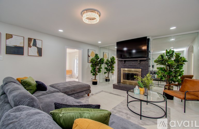 A living room with grey couches and a fireplace.