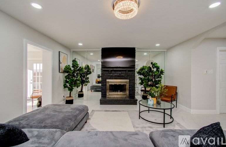 A modern living room with a grey sofa and a fireplace.