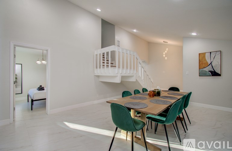 A dining room with a wooden table and green chairs.
