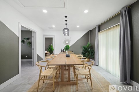 A modern dining room with a wooden table and chairs.