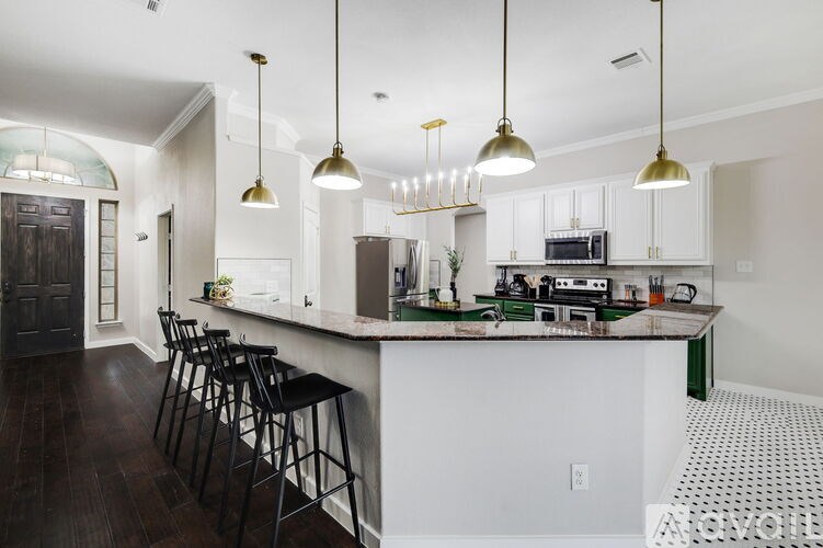 A kitchen with a white counter and black stools.