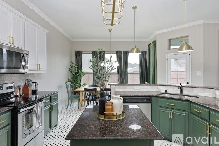 A kitchen with green cabinets and a black and white floor.