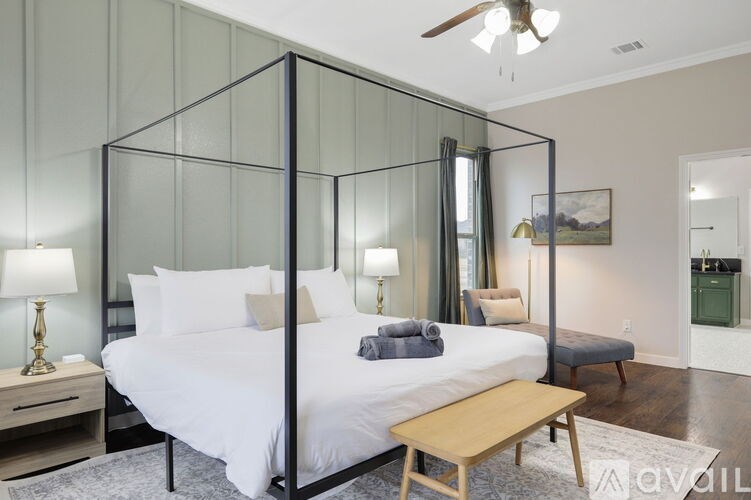 A bedroom with a four poster bed and a ceiling fan.