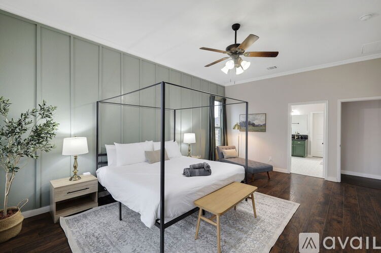 A bedroom with a four poster bed and a ceiling fan.