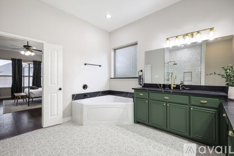 A bathroom with a green cabinet and a white bathtub.