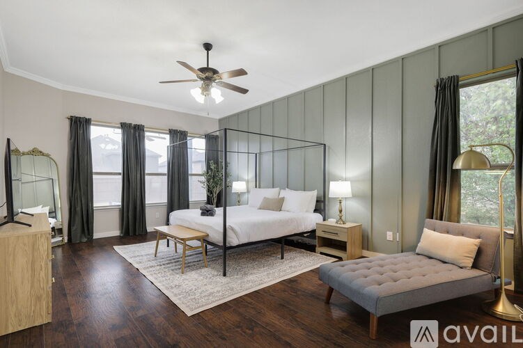 A bedroom with a large bed, a bench, and a side table with a lamp.