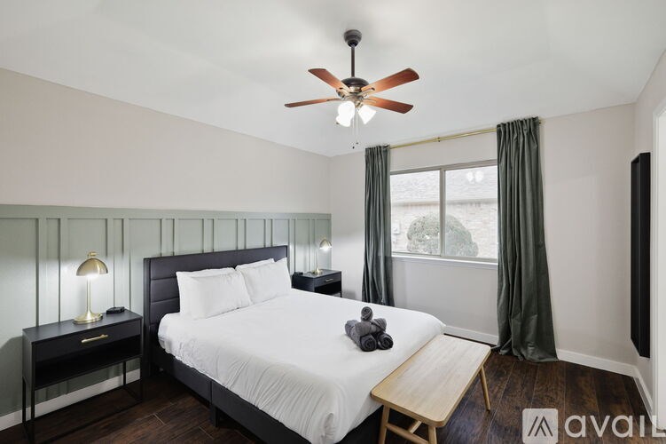 A bedroom with a bed, nightstand, and window.
