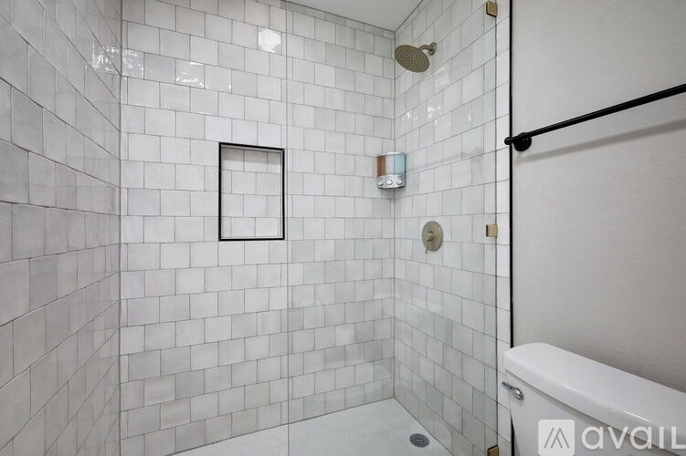 A white tiled bathroom with a shower and a bathtub.