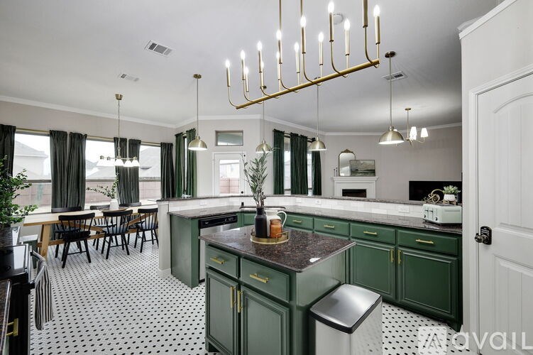 A kitchen with green cabinets and a black and white checkered floor.