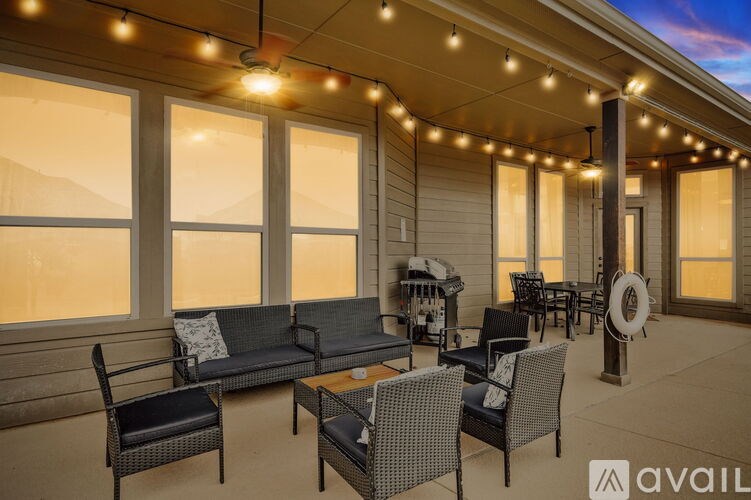 A patio with black furniture and string lights.