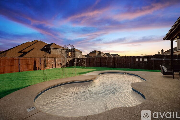 A backyard with a pool and a fence.