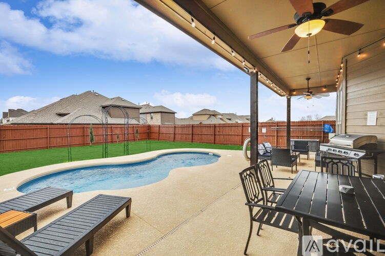 A patio with a table, chairs, and a pool.