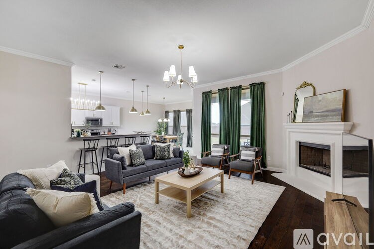 A living room with a dark blue couch, a wooden coffee table, and a fireplace.