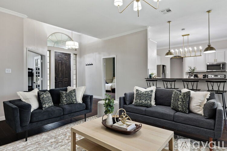 A living room with a black couch and a coffee table.