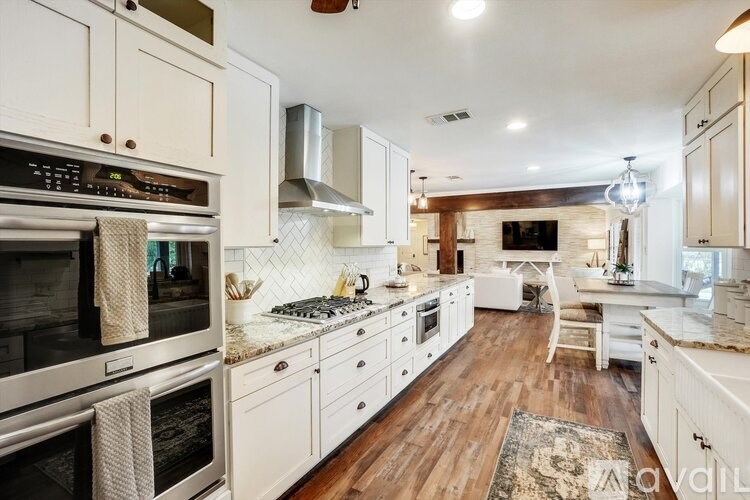 A modern kitchen with white cabinets and stainless steel appliances.