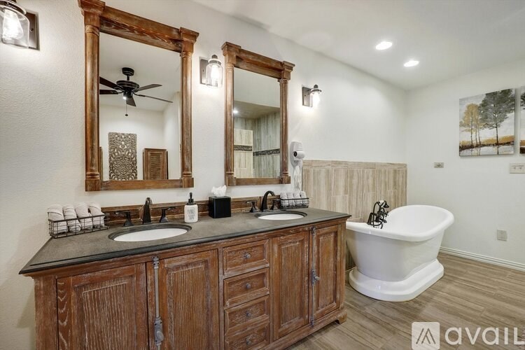 A bathroom with a wooden vanity and a white bathtub.