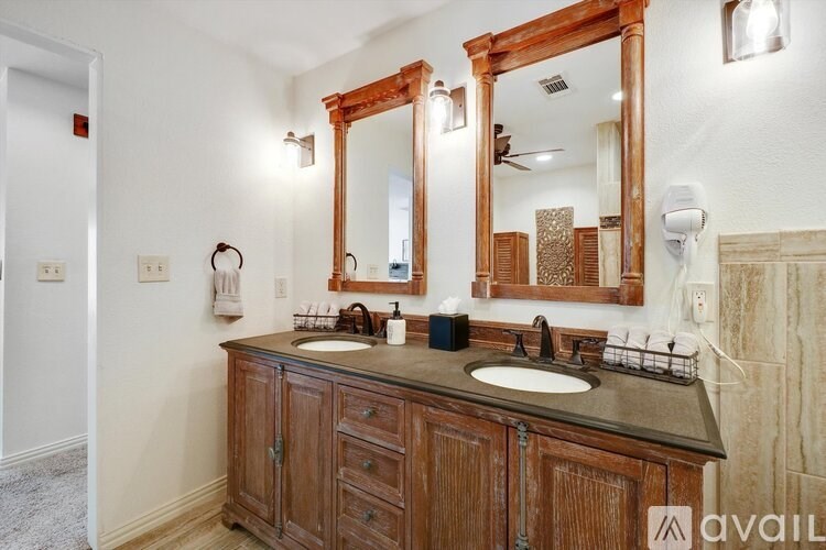 A bathroom with a wooden vanity and two sinks.