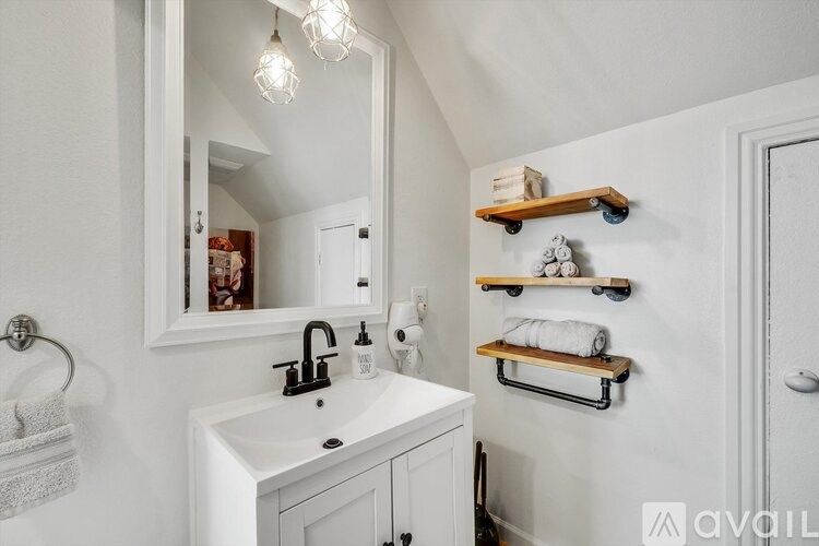 A bathroom with a white sink and a mirror.