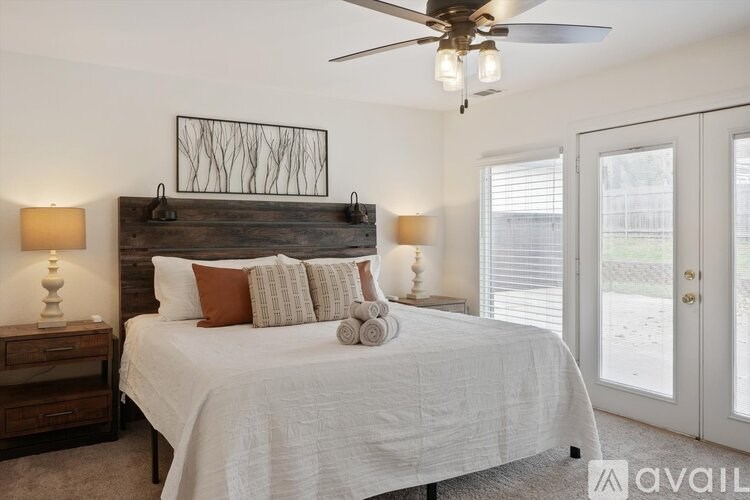 A bedroom with a bed, nightstands, and a ceiling fan.