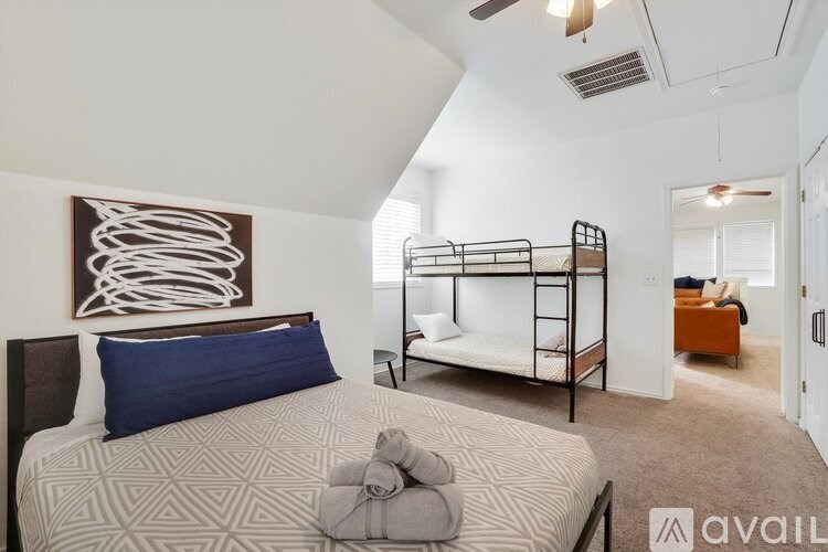 A bedroom with a bed, a bunk bed, and a painting on the wall.