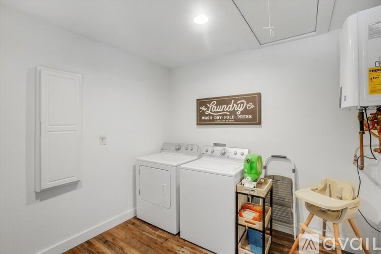 Laundry room with washer and dryer and a baby chair.